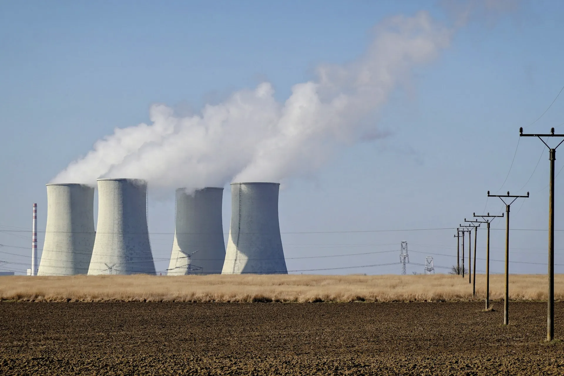Industry context: Nuclear power station cooling towers under a blue sky.