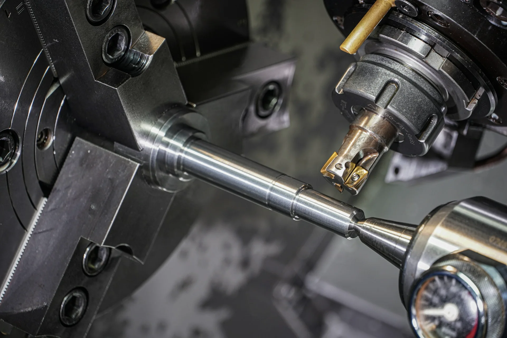 Industry context: Metal shaft held in a lathe during machining.