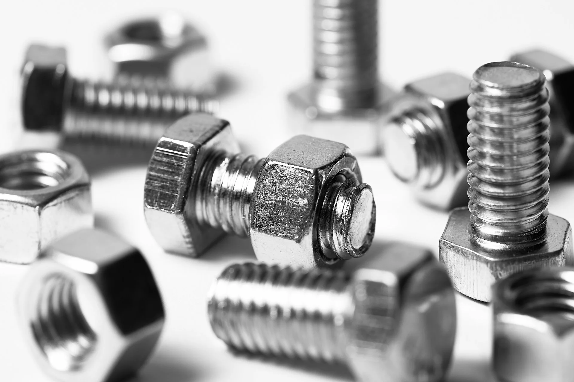 Industry context: Metal nuts and bolts on a light background.